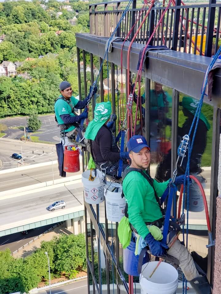 Presto technicians hanging on ropes performing glass restoration and waterproofing services on Cincinnati office building