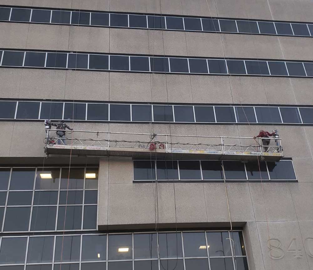 Presto crew using swing stage for office building restoration