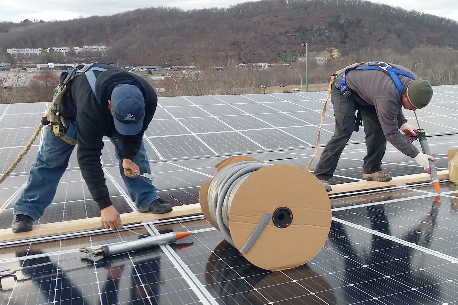 Presto technicians applying waterproofing solution to current solar panel installation