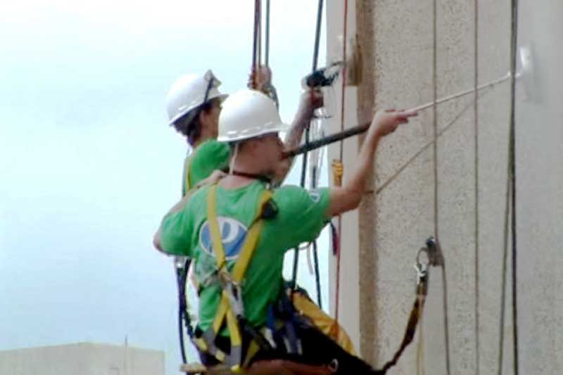 Using rappelling equipment to clean and seal an office building in West Virginia